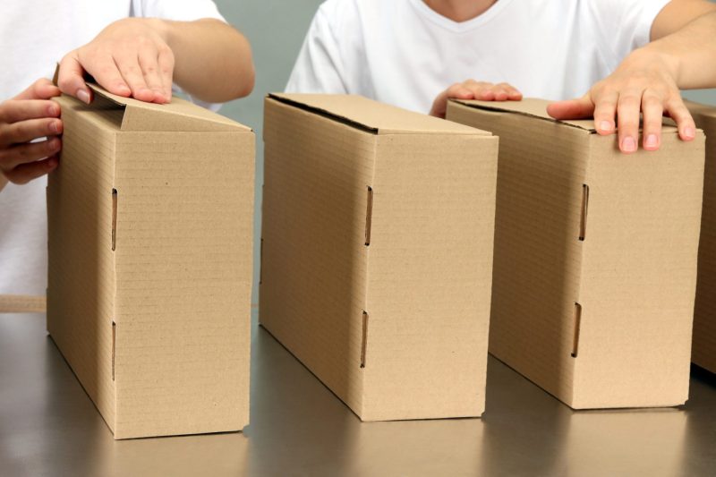 persons holds cardboard packages